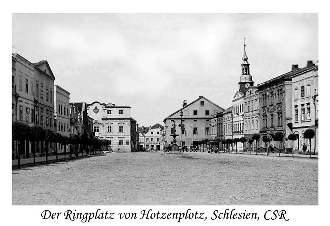Hotzenplotz_Ringplatz.jpg - Wikimedia Commons, volné dílo (public domain) Historické náměstí v Osoblaze s kašnou, radnicí a řadou měšťanských domů.